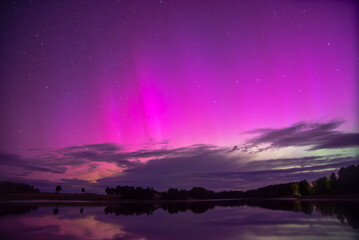 a red northern bleak on the shore of a lake on a starry night