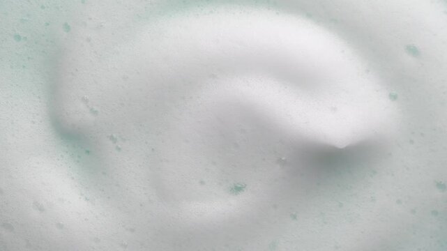 Foam texture swirl backdrop. Liquid soap bubbles background, Froth bubbles backdrop. Soap foam popping bubble rotating. Soap sud macro structure close-up. Clean, cleaning, washing, laundry