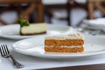 delicious cake with green cream, topped with fresh, fragrant strawberries and delicious cake with white buttercream, white sponge layers, and fresh nuts, served on a beautiful white plate on a wooden 