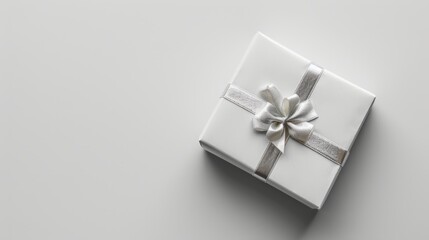 Elegant white gift box with silver ribbon on a minimalist background