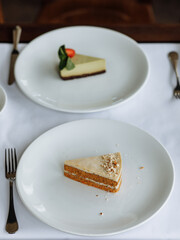 delicious cake with green cream, topped with fresh, fragrant strawberries and delicious cake with white buttercream, white sponge layers, and fresh nuts, served on a beautiful white plate on a wooden 