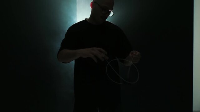 guy professionally spins yo yo, rope tricks, great background, light through fog