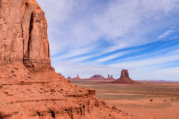 Fototapeta premium Breathtaking landscape of Monument Valley from the North Window Overlook in Arizona, showcasing iconic red rock formations under a vast blue sky. The stunning beauty of the American Southwest - USA