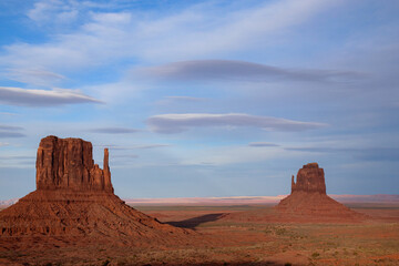 Panoramic view of the Monument Valley Mittens in Arizona, USA. The iconic red sandstone buttes stand majestically against a blue sky, representing the stunning landscapes of the American Southwest.