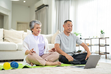 Portrait of sport senior asian couple training and sitting relax practicing yoga, elderly health, fitness, exercise, wellness, workout, sport at home.retirement concept.Fitness senior healthy