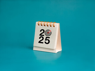 Happy new year 2025 background. 2025 number with target dart icon on white small desk calendar...