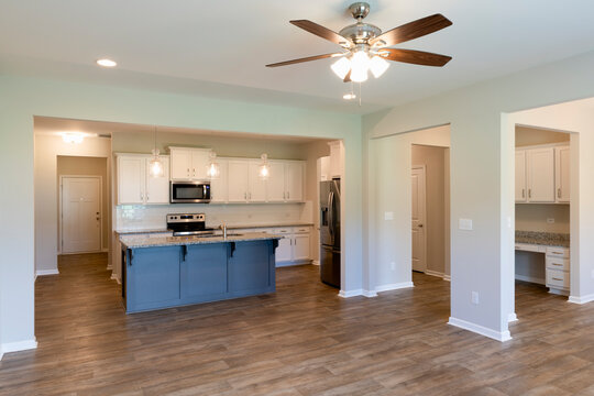 Empty modern townhouse floor showcasing a kitchen with living and dinning room ready to be moved in. Investment, renting, or house ownership concept