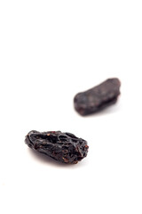 Black raisins on a white background. Dried fruits.