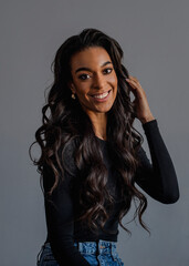 Happy african american female sitting against gray background