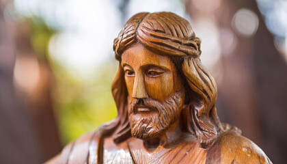 Close-up of wooden Jesus Christ wooden sculpture. Handmade art. Religion and faith