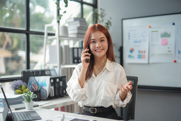 Smiling businesswoman is having phone conversation and discussing new project with her business partners