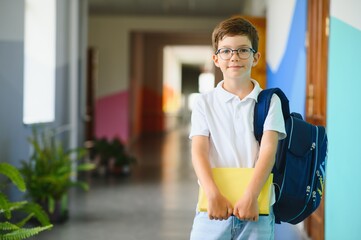 Portrait confident schoolboy in school corridor
