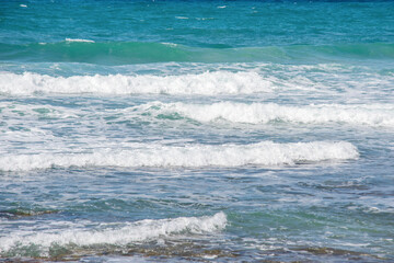 Gentle waves lapping on serene beach under bright sun in tropical paradise