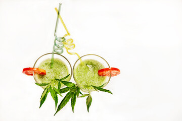 two glasses with nutritious hemp smoothie decorated with tomato mugs on a light background, hemp...