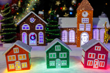 Christmas town made of colorful houses of different sizes among the Christmas trees