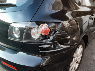Close-up of a car that suffered a rear-end collision with broken bumper, mudguard and rear light