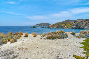 Obraz premium Scenic landscape of rocky coast of Mediterranean Sea - Crete, Greece. Beautiful blue sky, mountains in the background.