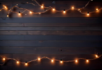 A dark, space surrounded by decorative string lights on top and bottom on a wooden background