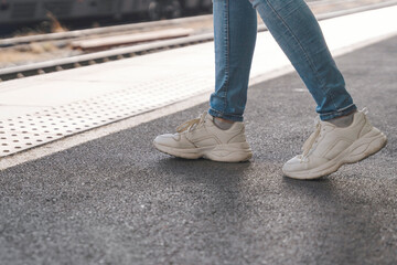 journey begins at train station platform during sunny afternoon with casual sneakers guiding way