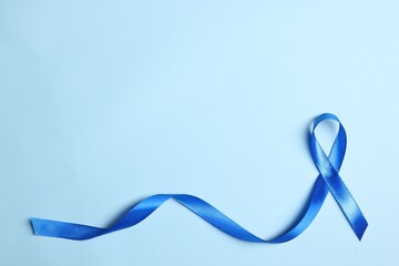 Blue ribbon on light background, top view with space for text. Prostate cancer awareness