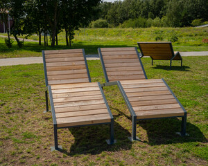 two wooden deckchairs against a background of green grass