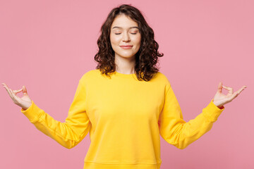 Young woman she wearing yellow sweatshirt casual clothes hold spreading hands in yoga om aum...