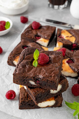 Cheesecake brownies with raspberry on a gray concrete background. Delicious dessert