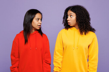 Two young shocked astonished happy little kid teen girls women they wearing red yellow hoodie...