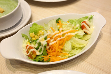 Tuna salad is served on a white plate on the dining table.