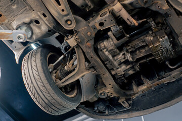 close-up at service station with a car under it that is raised on a lift bottom of the car
