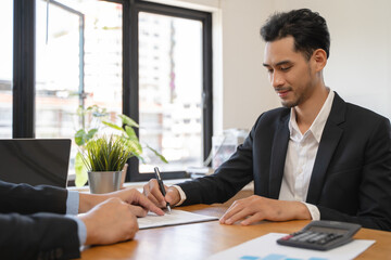 businessman sitting at desk holds pen signing contract paper, lease mortgage, employment hr or...