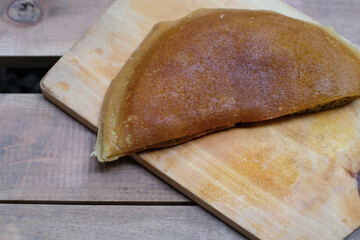 Martabak manis or terang bulan is indonesian sweet pancake, on wooden cutting board, homemade, sweet food.