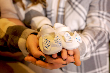 Pregnant woman with her husband holding baby booties, close-up