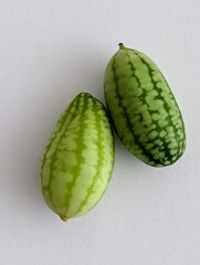 Zwei kleine Mexikanische Mini-Gurken auf weißem Hintergrund 