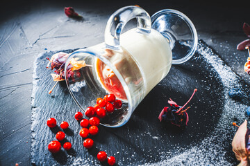 Original serving of the dessert panna cotta with lingonberries, blueberries in a glass lying on a...