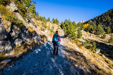 Young hiker woman in autumn in Aiguestortes and Sant Maurici National Park, Spain