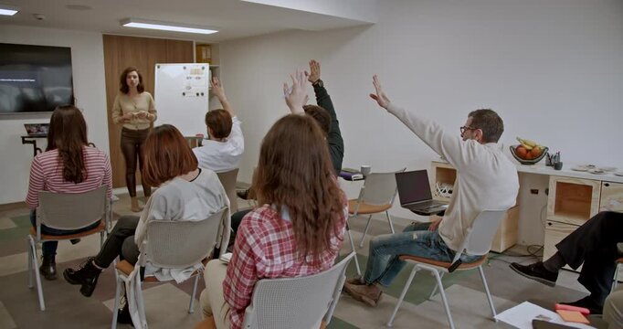 Employees engage in a team seminar with a business coach in a classroom, discussing strategies and improving skills, aiming for enhanced performance and growth.