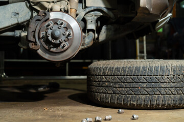 Car wheel and brake disc at repair shop. Auto service industry.Remove the car wheels and prepare for repairs to the brake and suspension systems.