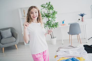 Photo of teen blonde sweet adorable lady hold device idea choose outfit dressed sleepwear apartment bedroom waking white light interior