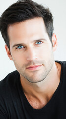 Obraz premium Man with short dark hair and blue eyes, black shirt.