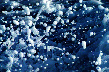 Splashes of water created in the wake of a motor boat photographed with a 300mm macro lens