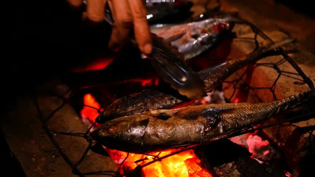 Selective focus of Grilling Cakalang fish or Skipjack tuna (Katsuwonus pelamis) on a cast iron grill. close up view