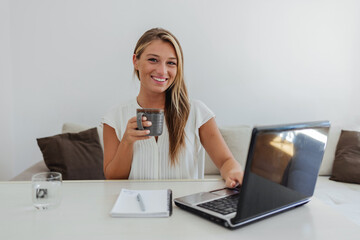 Coffee, laptop and remote work with woman in home office for small business or startup administration. Computer, drink and entrepreneur person in apartment to research target audience information.