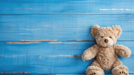 Adorable teddy bear on blue wooden background with space for text