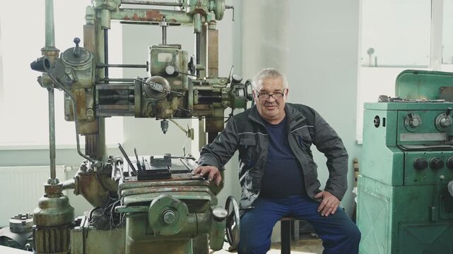 Cinematic portrait of an elderly senior professional worker turner milling machine smiling on camera, huge extensive work experience