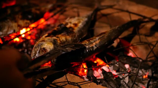 Selective focus of Grilling Cakalang fish or Skipjack tuna (Katsuwonus pelamis) on a cast iron grill. close up view