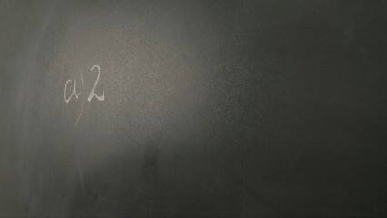 Close up of woman hand writing math sample and formula on chalkboard, professor writes on...