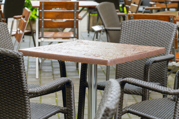 Table and chairs on the summer terrace of a restaurant after the rain.