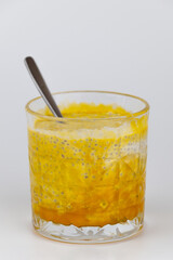 Chia pudding with coconut milk and mango puree in a glass on a white background.