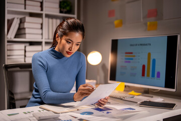 A woman is sitting at a desk with a computer monitor